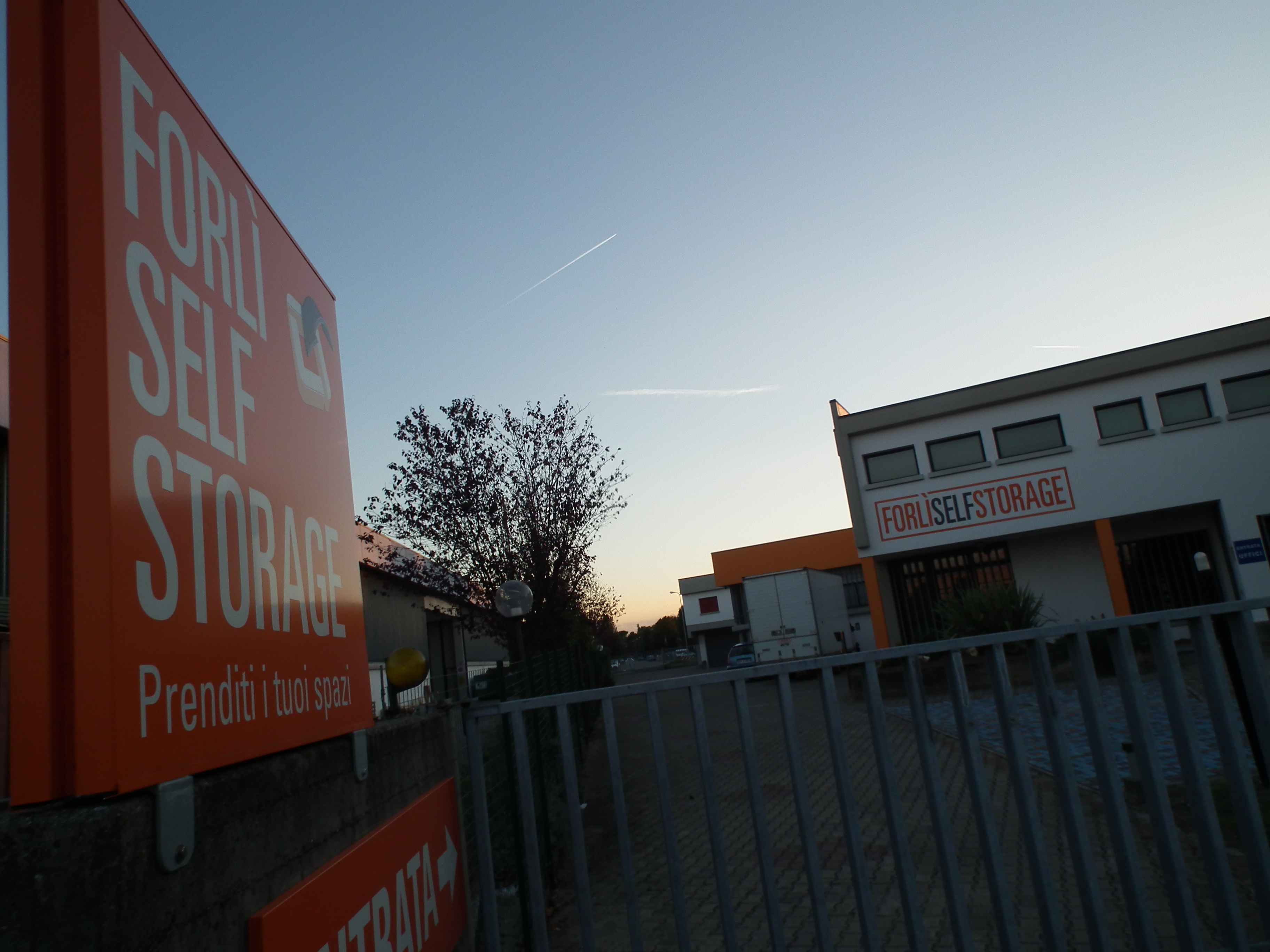 Ingresso di Romagna Self Storage al tramonto con insegna illuminata
